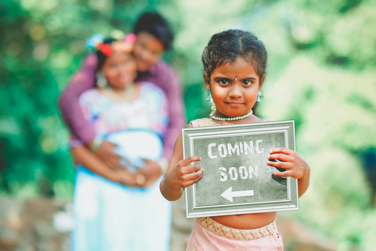 A girl holding a coming soon sign.